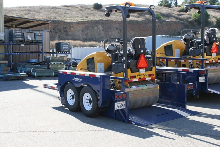 Air-Tow drop deck trailer lowered to the ground loading a Volvo smooth drum roller compactor