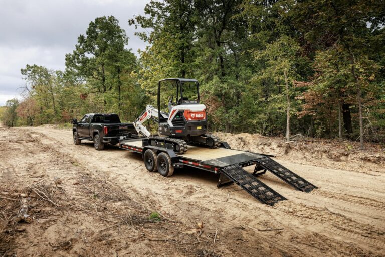 Bobcat mini excavator loaded on a Maxx-D fender low-profile equipment trailer with fold-out ramps