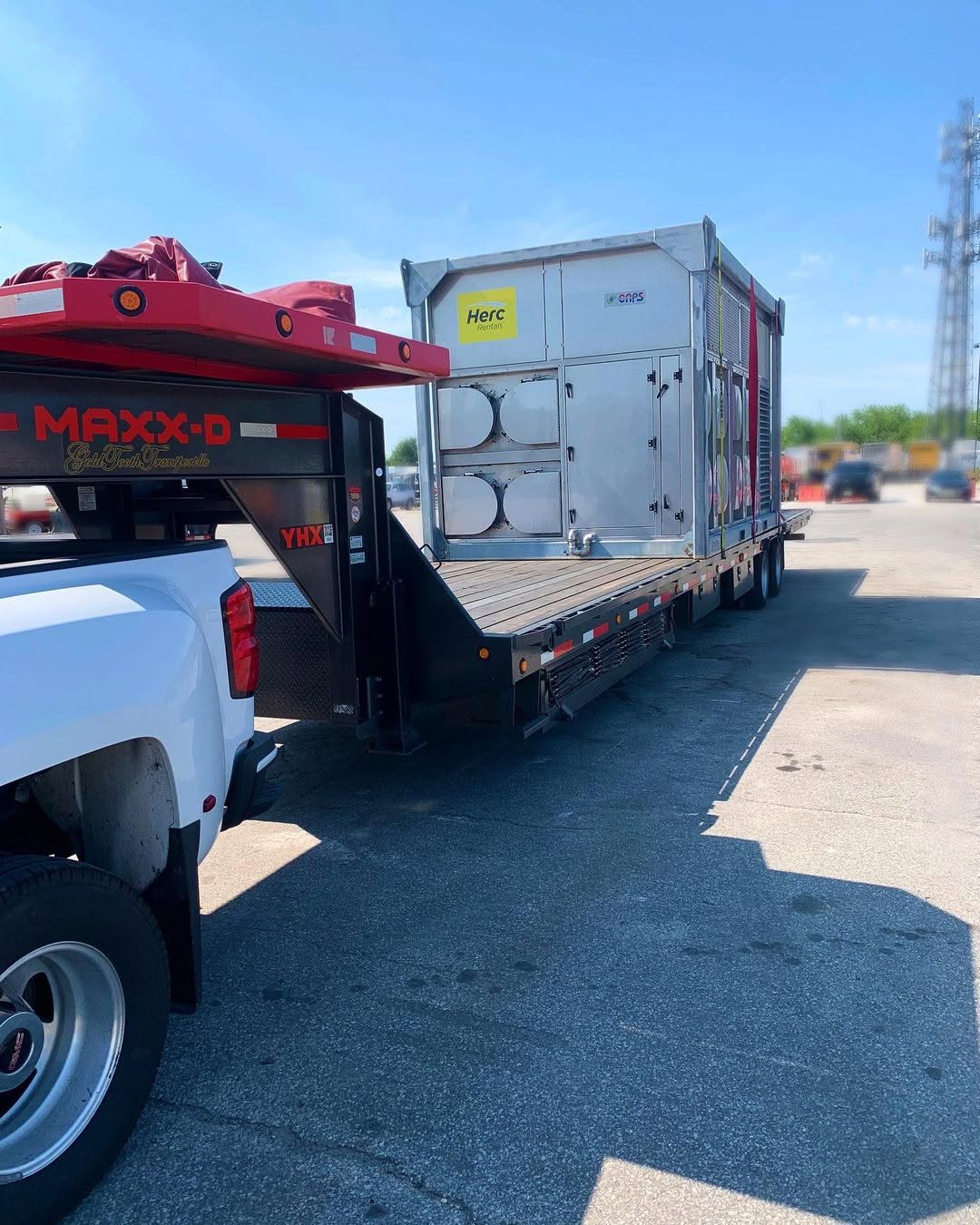 Pickup towing a Maxx-D gooseneck flatbed loaded with a large HVAC unit