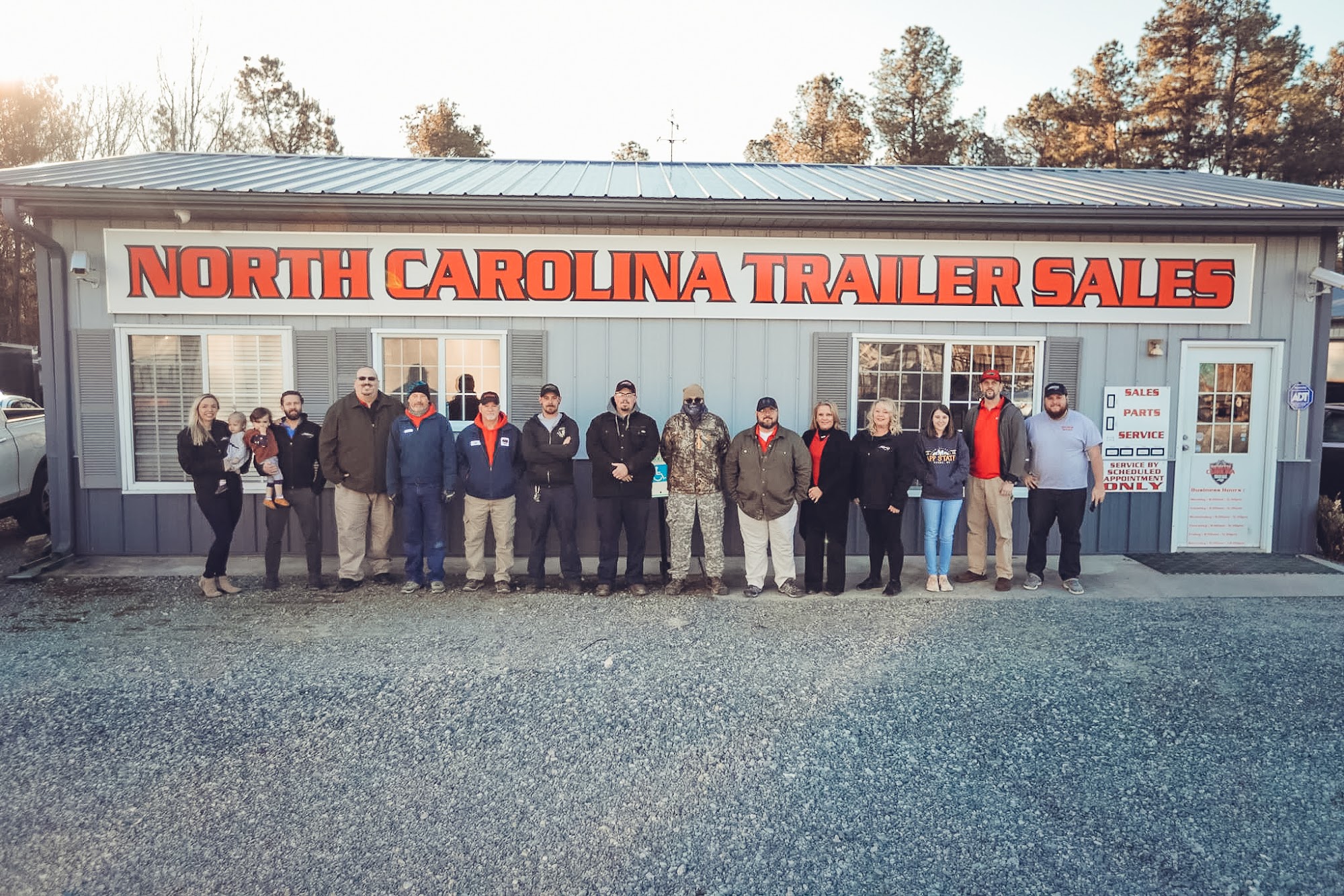 The NC Trailers team standing in front of the North Carolina Trailer Sales building in Thomasville