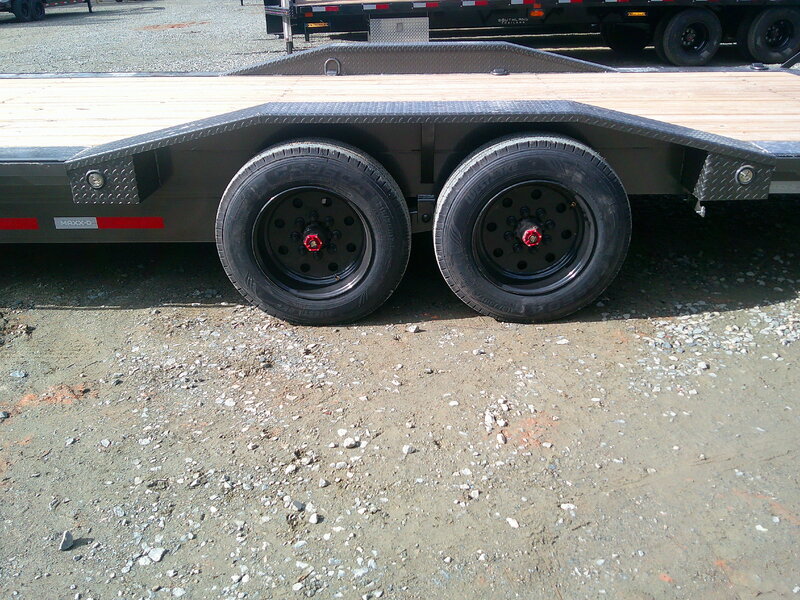 Low drive-over fenders over the tandem axles of a Maxx-D H8X equipment trailer on the NC Trailers lot