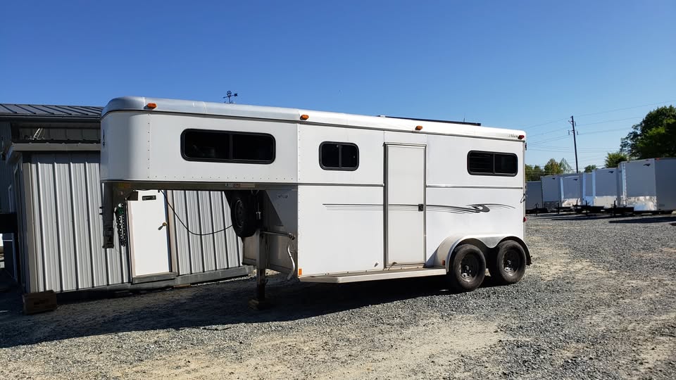 Used two-horse gooseneck trailer parked at NC Trailers