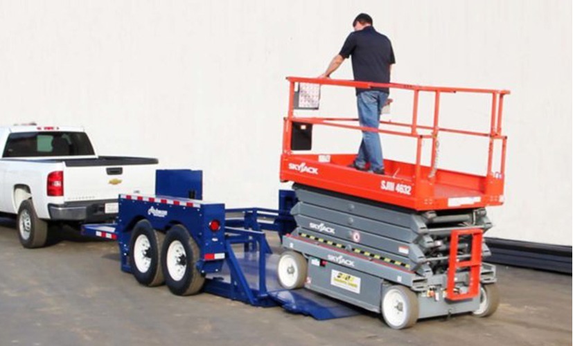 Air-Tow drop deck trailer lowered to the ground with a scissor lift driving on