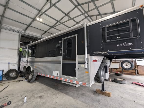 Living quarters horse trailer up on jack stands in the NC Trailers service bay
