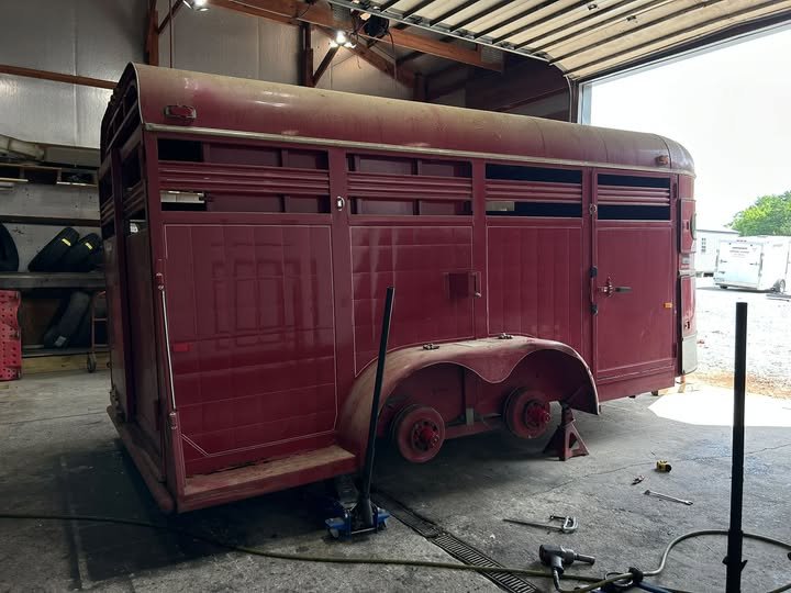 Livestock trailer on jack stands with the wheels off in the NC Trailers service shop
